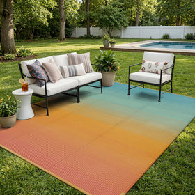 Lahome camping rug in blue-orange gradient, waterproof surface for outdoor use beside the RV.