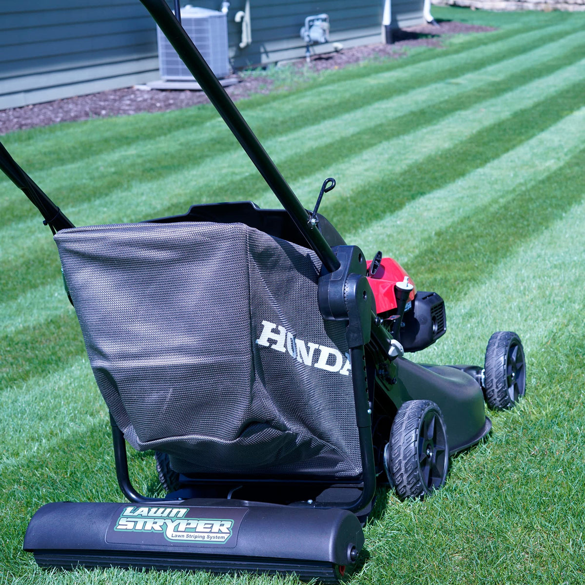 Lawn Stryper Gen 3 cover attached to Honda mower enables simultaneous mowing and stripe patterning