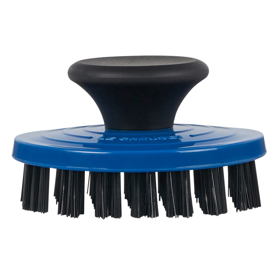 Le Creuset grill pan brush closeup showing nylon bristles for stubborn residue removal.