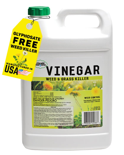 Liquid Harvest Vinegar Weed & Grass Killer bottle spraying weeds in a garden setting
