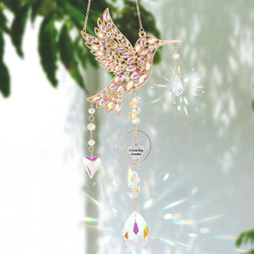 LOKOZ hummingbird sun catcher creating sunlit reflections on a window