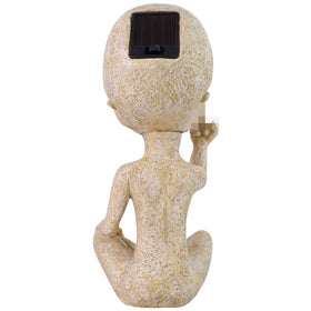 Lopoti Solar Light Alien Statue beside flowers for a charming yard focal point.