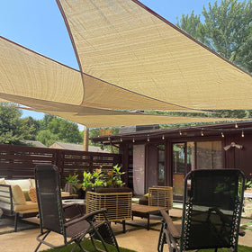 LOVE STORY triangle sand shade sail over patio provides UV protection and shade.