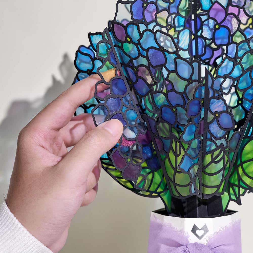 Lovepop hummingbird detail adds graceful movement to birthday decor.