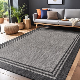 Luul Home bordered outdoor rug in dark gray enhances indoor and outdoor spaces