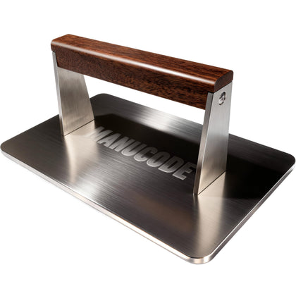Manucode stainless bacon press, top view, showing even searing potential on a flat grill.