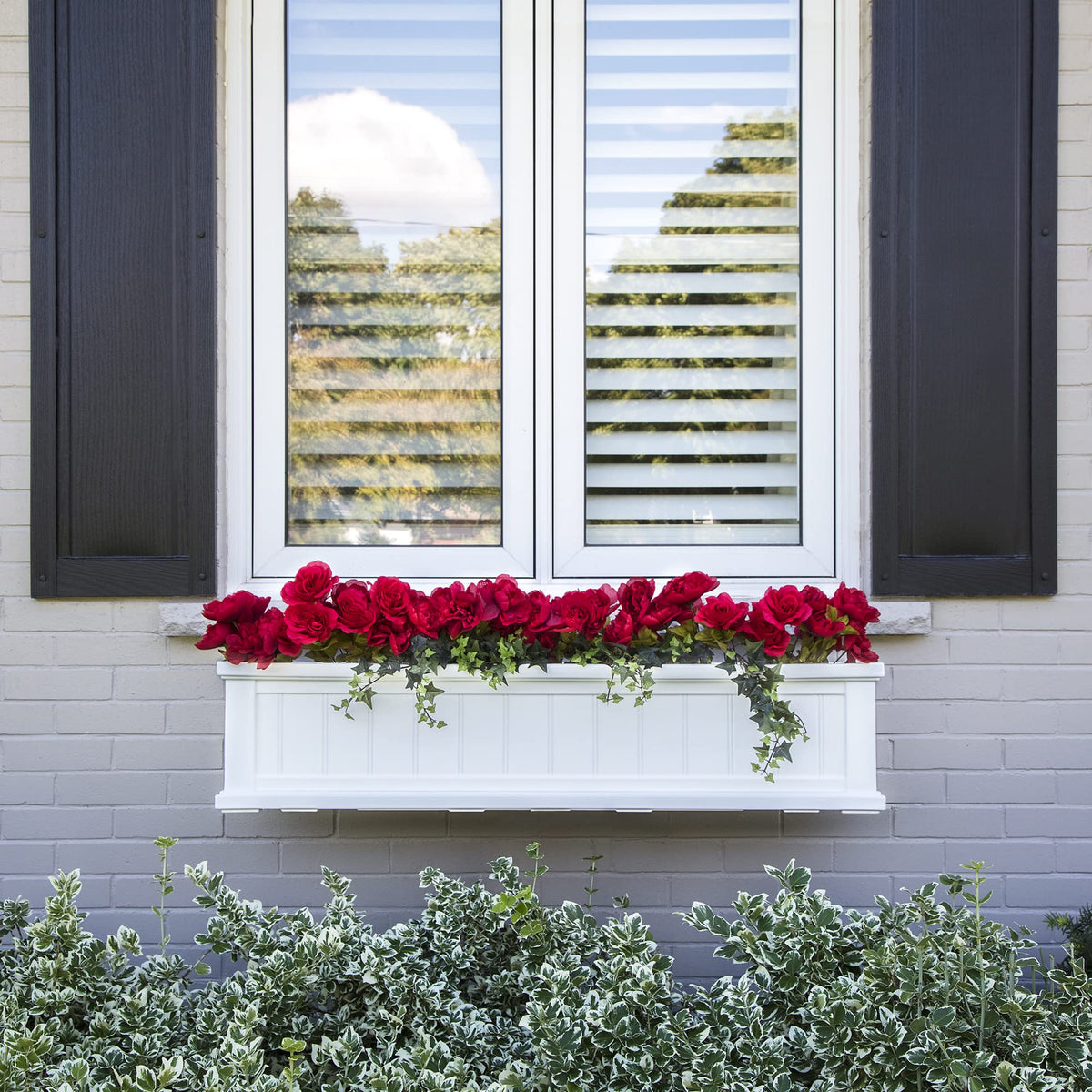 Mayne Cape Cod white window box on a patio with lush greenery