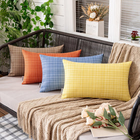 MIULEE orange outdoor pillow cover styled on a sunny patio setup