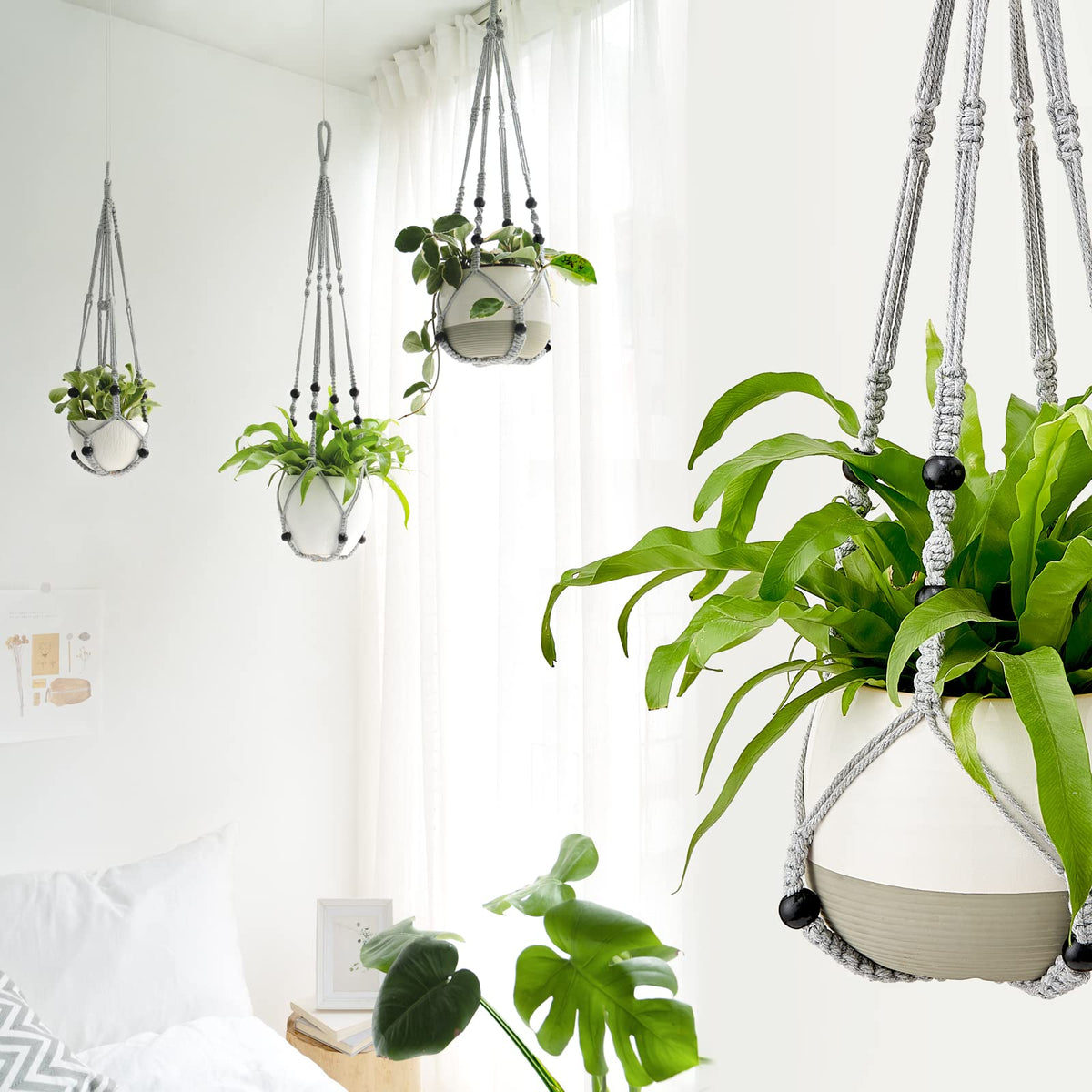 Mkono macrame indoor/outdoor hanger displayed with plant on balcony.