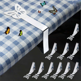 MONNCHA butterfly tablecloth clip in use secures a cloth on a windy outdoor table