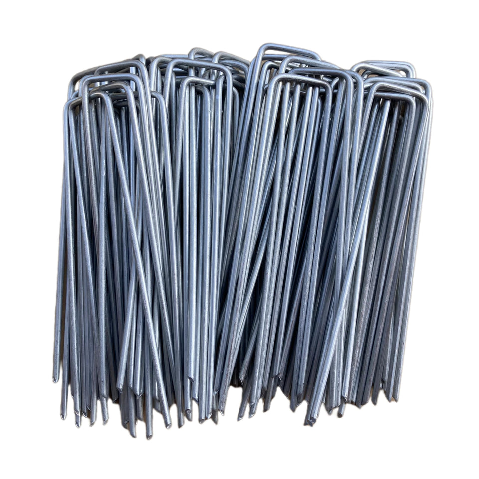 MPHKFDE 6-inch galvanized garden stake penetrating soil to secure landscape fabric.