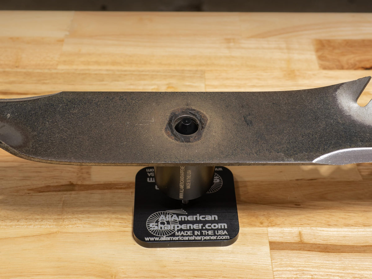 Mulching blade sharpening with pivoting head for precise angle control.