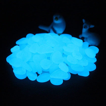 Muzero Glow Pebbles glow blue in an aquarium after sun exposure, ideal decor