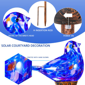 Dark blue bird glass stake by Naboher along a garden border