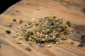 New Country Organics Goat Feed ingredients close-up showing organic grains and minerals.