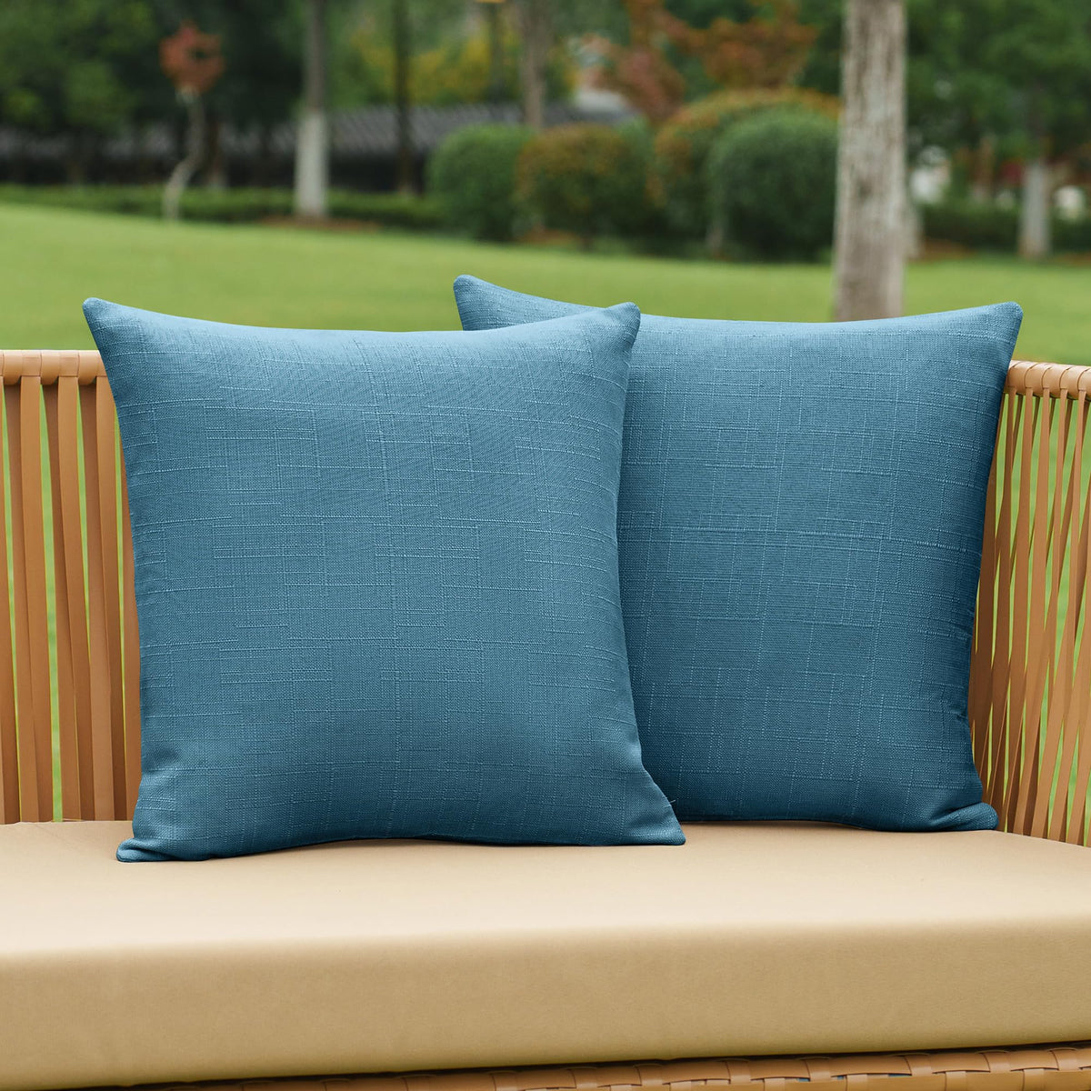 NiNi ALL dark blue outdoor pillow cover on a patio chair with textured linen finish