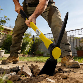 Nohovu pickaxe digging in soil showing broad blade in action