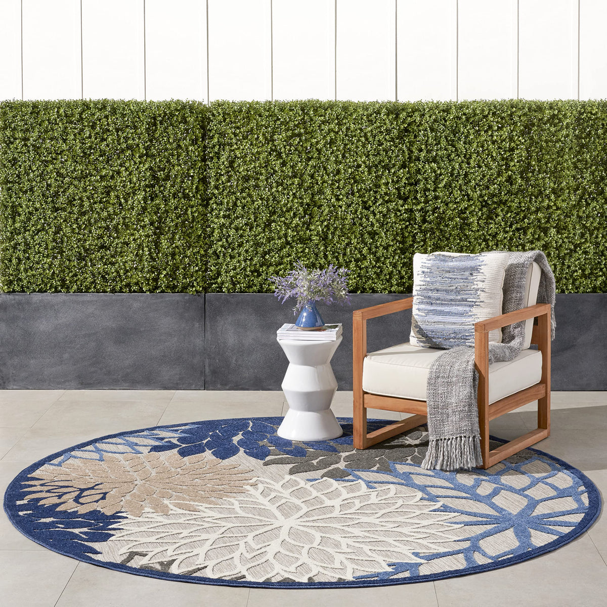 Nourison Aloha round rug in blue multicolor floral design for outdoor spaces.