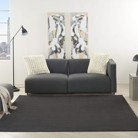 Nourison Essentials Black 5' x Square rug in living room, stylish and versatile.