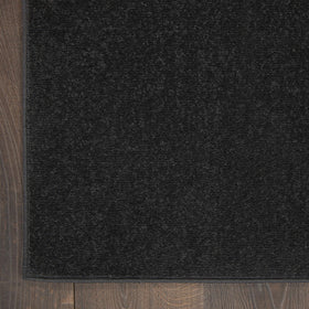 Nourison Essentials Black 5' x Square rug, low-pile design stays flat under furniture.