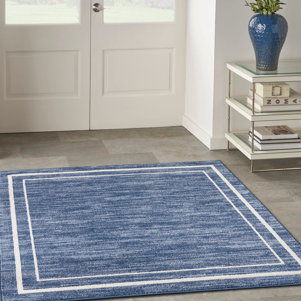 Nourison Essentials Navy/Ivory border detail rug defines space with durable edges, suitable for indoors or outdoors.