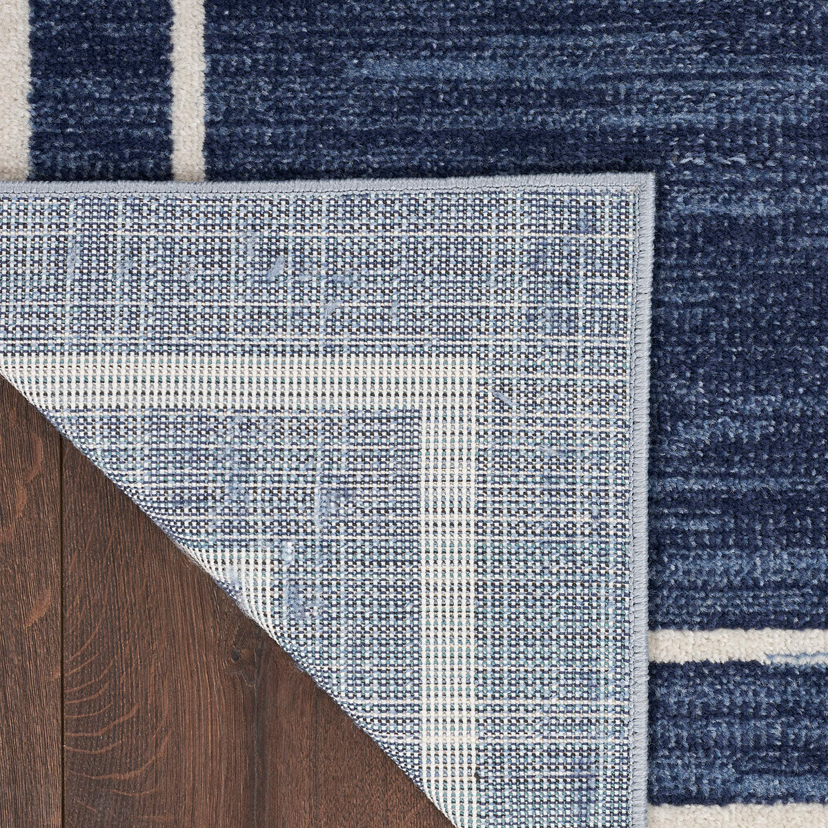 Nourison Essentials Navy/Ivory easy-clean label emphasizes hose rinsing for quick cleanup.