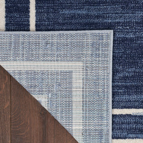 Nourison Essentials Navy/Ivory easy-clean label emphasizes hose rinsing for quick cleanup.