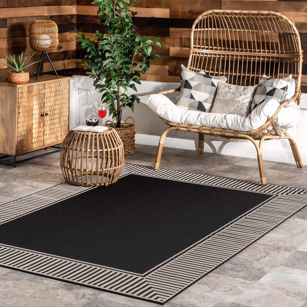 nuLOOM Asha rug with striped border defines indoor/outdoor seating areas.