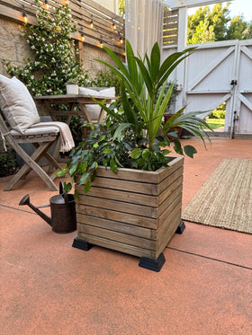 OAKENZ corner feet under square planter, improving drainage and protecting decks