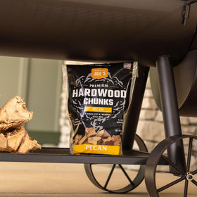 Oklahoma Joe's Pecan Wood Chunks in smoker enhancing flavor with consistent heat.