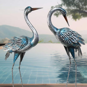 Oritty blue crane statues provide eye-catching garden decor.