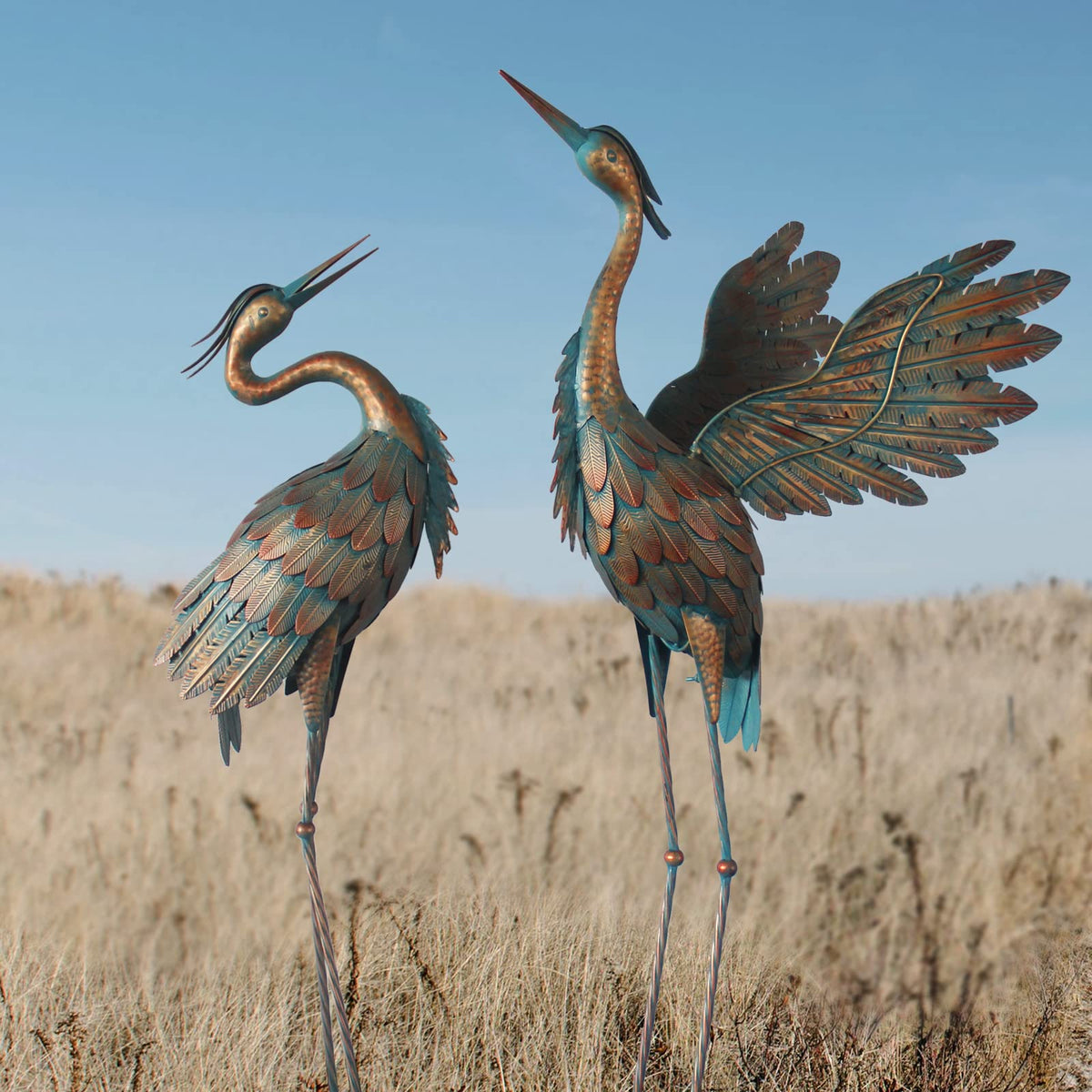 Oritty crane statues add elegant garden charm with copper finish for outdoor decor.