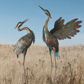 Oritty crane statues add elegant garden charm with copper finish for outdoor decor.