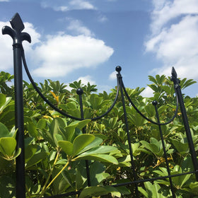 OUTOUR black-finish trellis blends with greenery and borders.