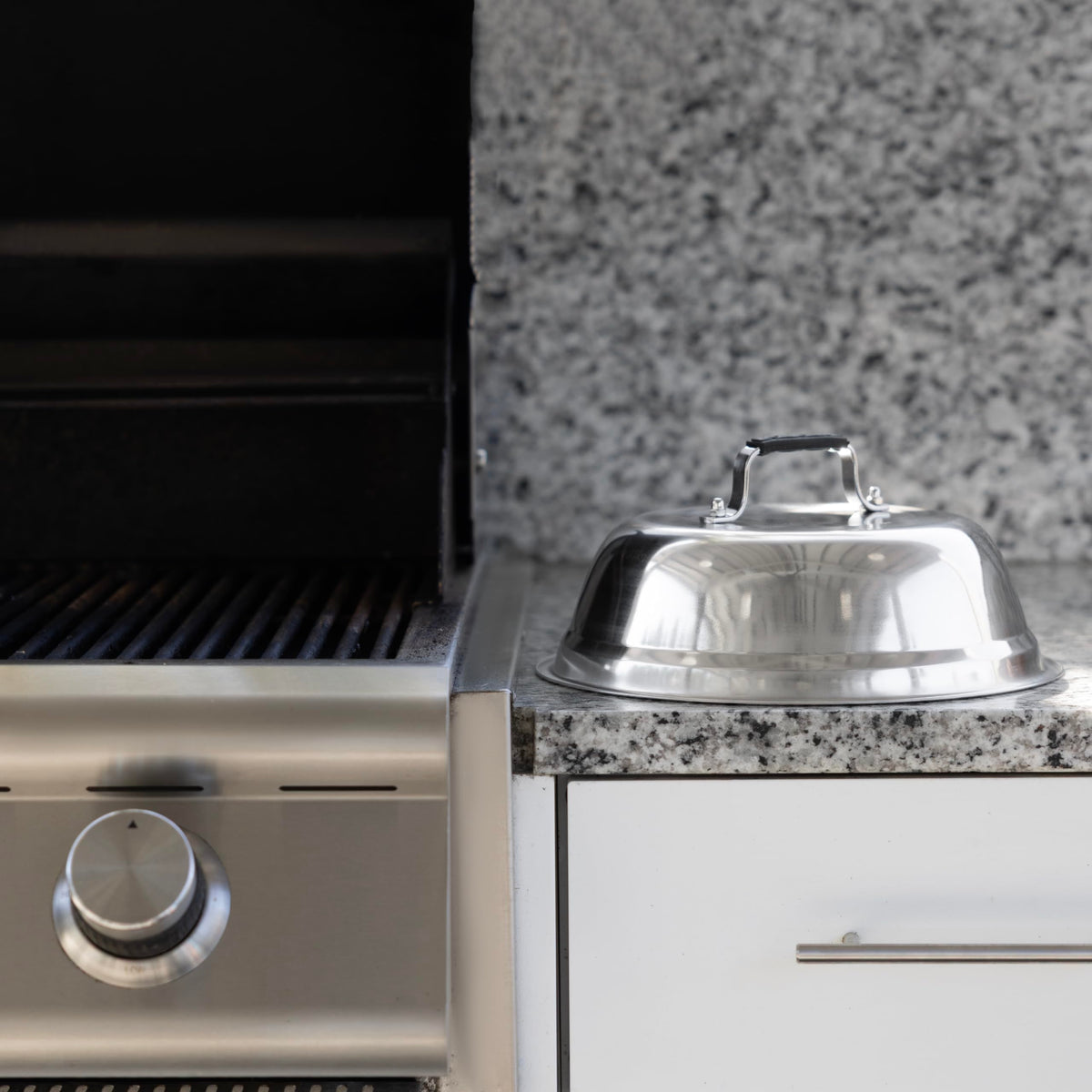 Outset stainless steel dome with silicone handle for easy lifting on stovetops.