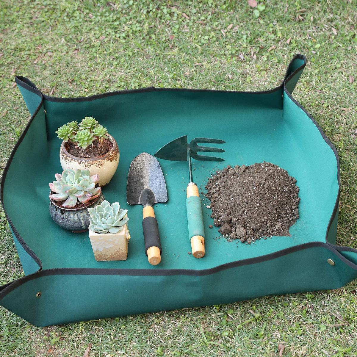 Owl Focus mat with snap-button corners containing soil during repotting for tidiness.