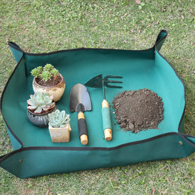 Owl Focus mat with snap-button corners containing soil during repotting for tidiness.