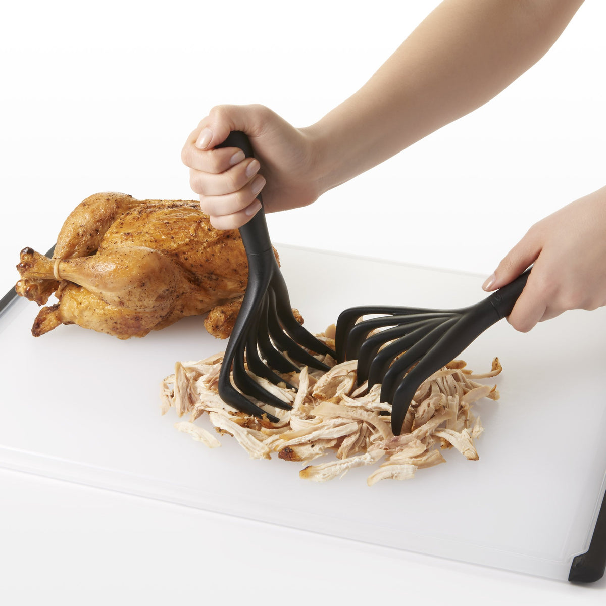 OXO Good Grips Meat Shredding Claws lifting shredded meat from a pan