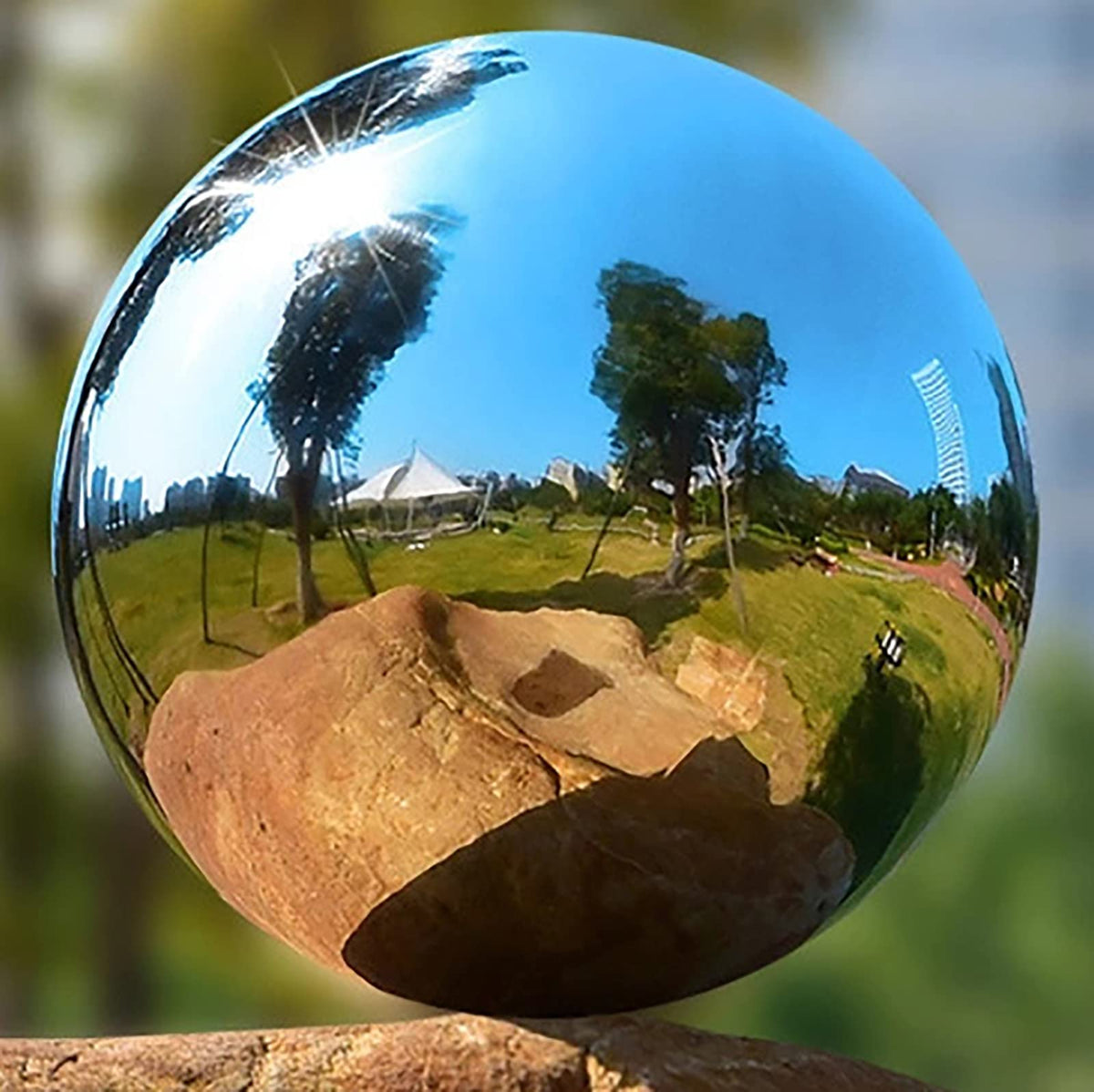 OZXNO Stainless steel mirror ball reflects garden scenes, enhancing outdoor ambiance.