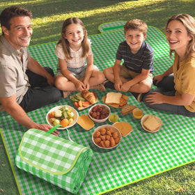 Pesilo picnic blanket green gingham laid out on grass for family seating.