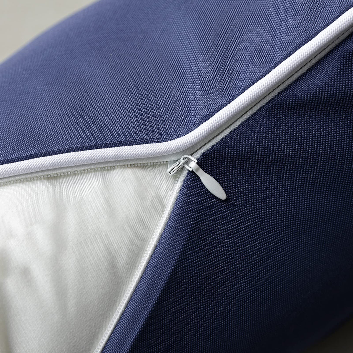 Phantoscope vibrant dark blue outdoor pillow cover shown in a garden setting.