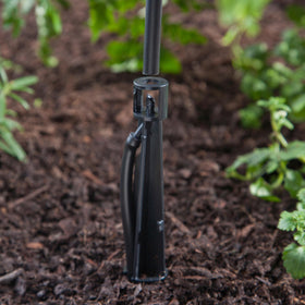 Raindrip stake enabling overhead watering for garden beds with low-flow emitters