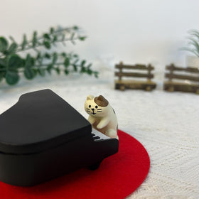 Refintural piano cat on red carpet enhances desk or shelf display