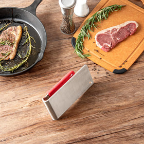 Restaurantware Met Lux steak press in use on grill delivering even sear.