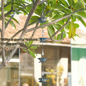 Retrome outdoor rain chain directs water from gutter to ground beside the patio
