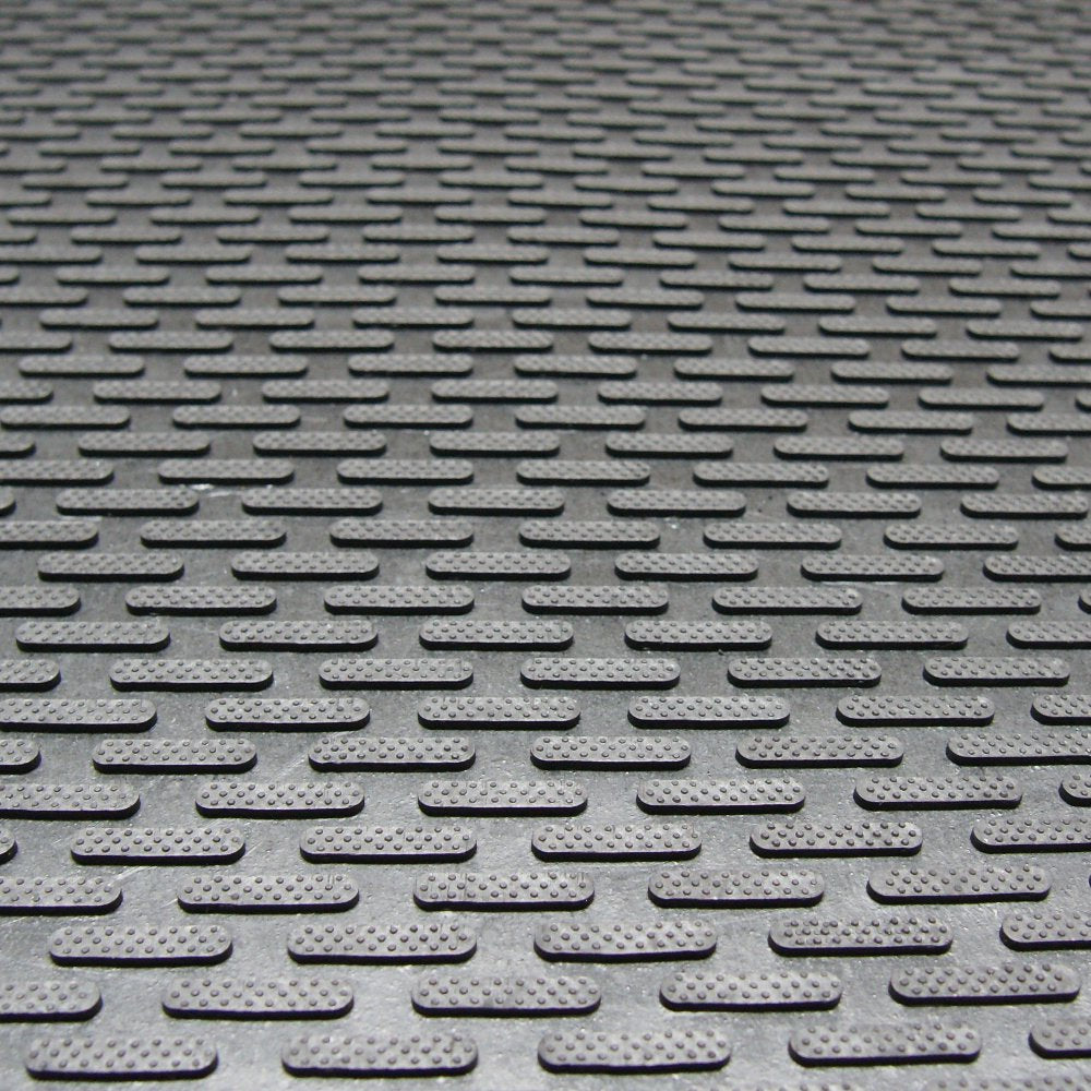Rubber-Cal Dura-Scraper Linear close-up shows raised protrusions scraping dirt at the threshold.