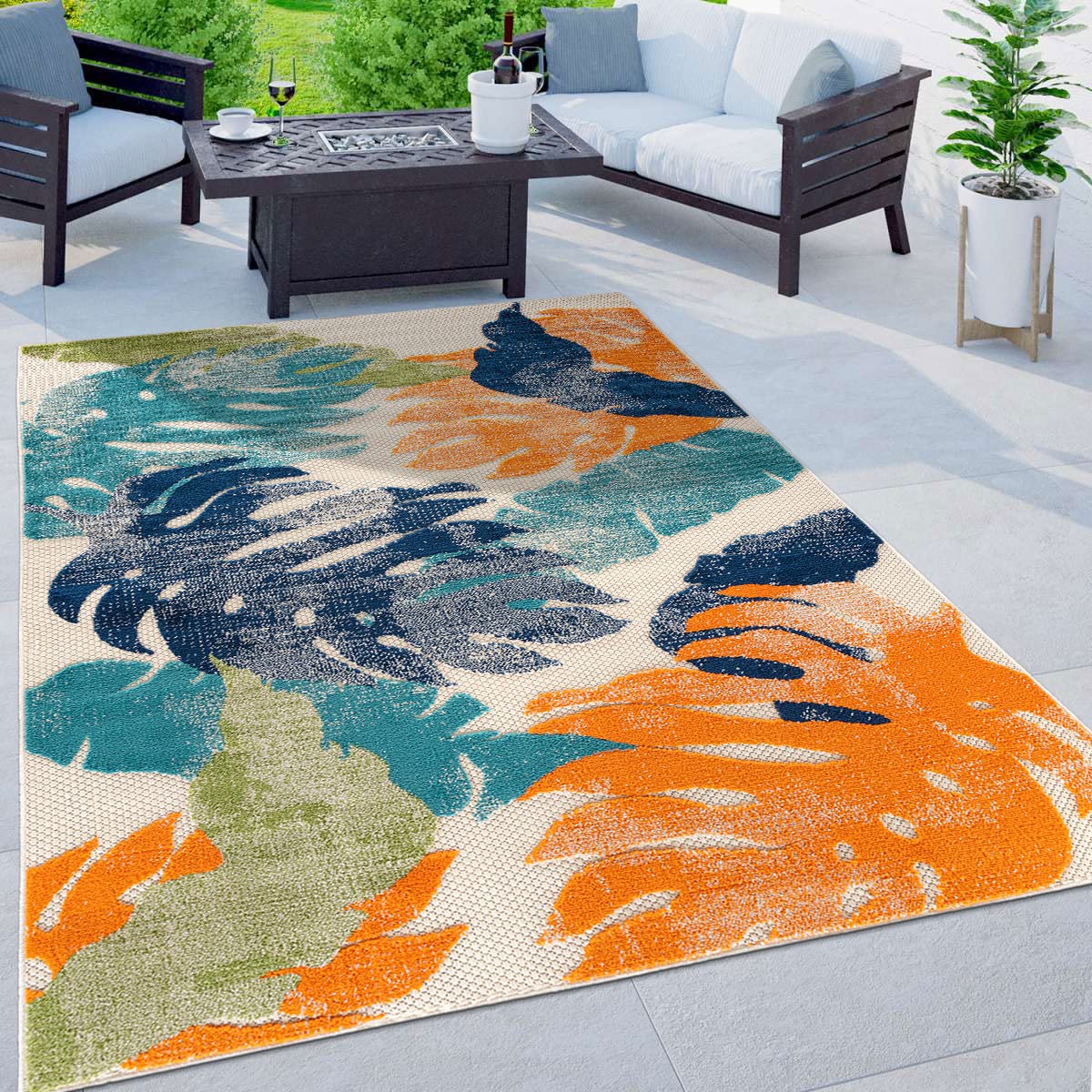 Rugshop Arles palm leaves outdoor rug on a sunlit patio showcasing fade-resistant colors.