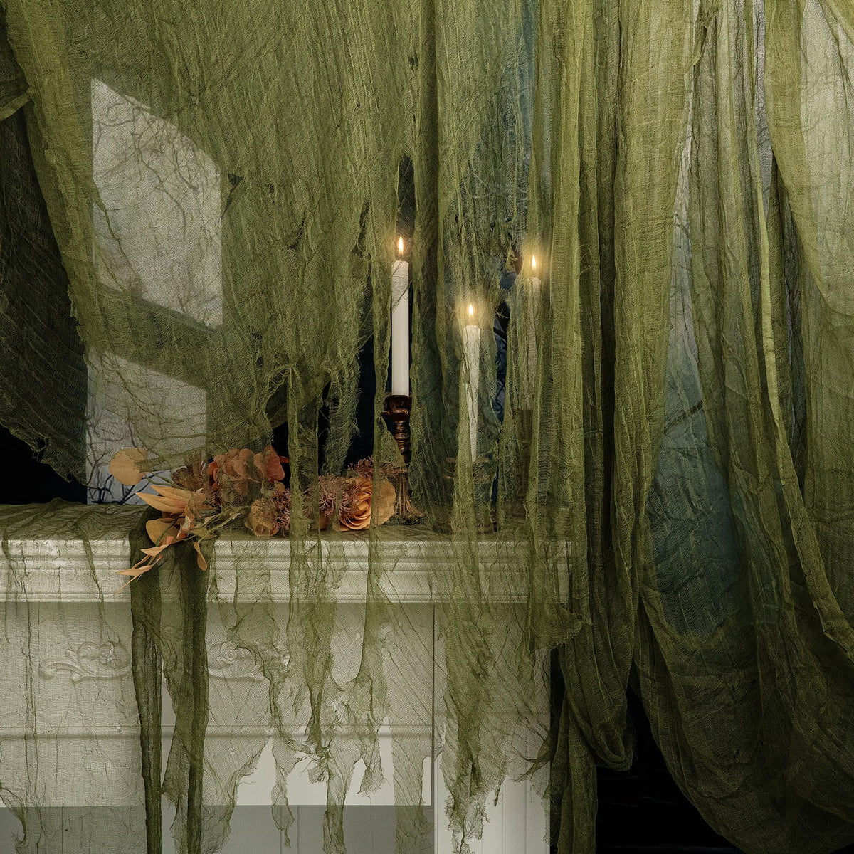 RunNico green Halloween cheesecloth draped on stairs for a spooky entrance.