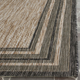 Safavieh Courtyard rug on a deck near a pool, ideal for outdoor entertaining.
