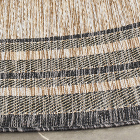 Safavieh Courtyard round rug outdoors in a seating area, weather-resistant and easy to clean.